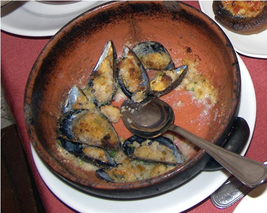 A gratin of mussels blanketed in breadcrumbs and olive oil.
